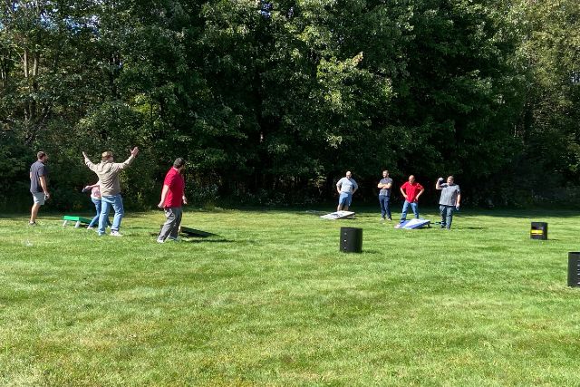 KSE fall picnic - employees playing cornhole in a field